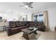 Spacious open-concept living space featuring a large leather sectional, tile floors, and modern ceiling fan at 15356 White Tail Loop, Mascotte, FL 34753