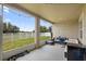 Outdoor patio featuring a grill, comfortable seating, and a serene view of the backyard and lush landscaping at 15356 White Tail Loop, Mascotte, FL 34753