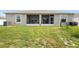 View of the screened in back porch with grass lawn and backyard at 15356 White Tail Loop, Mascotte, FL 34753