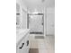 Modern bathroom featuring a sleek glass shower, white cabinets and neutral tile floor at 15356 White Tail Loop, Mascotte, FL 34753