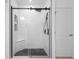 Modern bathroom boasts a glass shower with sleek black fixtures and a tiled floor at 15356 White Tail Loop, Mascotte, FL 34753