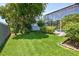Green backyard showcasing a well-kept lawn, diverse foliage, and a partial view of the pool area at 1676 Bear Crossing Cir, Apopka, FL 32703