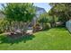 Lush backyard featuring a manicured lawn, mature trees, and a screened pool area for relaxation at 1676 Bear Crossing Cir, Apopka, FL 32703