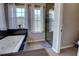Bright bathroom with soaking tub and a separate glass enclosed shower, complemented by natural light from multiple windows at 1676 Bear Crossing Cir, Apopka, FL 32703
