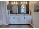 Elegant bathroom featuring double sinks with marble countertops and stylish mirrors against a dark accent wall at 1676 Bear Crossing Cir, Apopka, FL 32703
