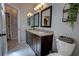 Bathroom with a dual sink vanity, granite countertop, decorative mirrors, and modern fixtures at 1676 Bear Crossing Cir, Apopka, FL 32703