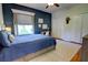 Stylish bedroom with a blue accent wall, offering a built-in bed, a study desk, and ample closet space at 1676 Bear Crossing Cir, Apopka, FL 32703