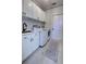 Bright laundry room features white cabinets, a sink, and modern appliances for easy and efficient laundry tasks at 1676 Bear Crossing Cir, Apopka, FL 32703