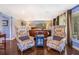 A primary bedroom with seating area featuring two arm chairs, natural light, and hardwood flooring at 1919 E South St, Orlando, FL 32801