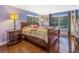 This bedroom features a wooden bed frame, wood flooring, and two windows with nice natural light at 1919 E South St, Orlando, FL 32801