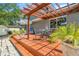 Backyard pergola and deck with table and chairs and manicured tropical foliage at 1919 E South St, Orlando, FL 32801