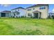 Backyard view of two-story homes with fenced yards and lush green lawns at 200 Azure Mist Way, Daytona Beach, FL 32124