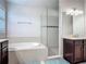 Bright bathroom with a soaking tub, shower, and a vanity, next to a large window at 200 Azure Mist Way, Daytona Beach, FL 32124