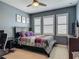 Comfortable bedroom features a bed, desk, and large window with plantation shutters at 200 Azure Mist Way, Daytona Beach, FL 32124