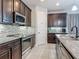 Modern kitchen features dark cabinetry, stainless steel appliances, and a stylish tile backsplash at 200 Azure Mist Way, Daytona Beach, FL 32124