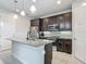 Modern kitchen features dark cabinets, stainless steel appliances, granite countertops and tile backsplash at 200 Azure Mist Way, Daytona Beach, FL 32124