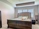 Comfortable main bedroom featuring a tray ceiling and window with white shutters at 200 Azure Mist Way, Daytona Beach, FL 32124