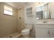 Well-lit bathroom featuring tiled shower, vanity, mirror, and built-in shelving at 2013 Dearing Ave, Deltona, FL 32725