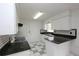 Bright kitchen featuring white cabinets, granite counters, and checkered backsplash at 2013 Dearing Ave, Deltona, FL 32725