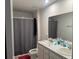 Bathroom with double sinks, shower with grey curtain, and a white toilet at 268 Fiddlewood Ct, Davenport, FL 33837