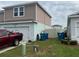Side exterior view of the house with green grass and garbage cans at 268 Fiddlewood Ct, Davenport, FL 33837