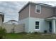 Side exterior view of the house with fence, green grass and bike at 268 Fiddlewood Ct, Davenport, FL 33837
