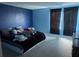 Bedroom featuring blue walls, a bed, and dark curtains at 268 Fiddlewood Ct, Davenport, FL 33837