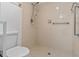 Tiled bathroom shower with handheld shower head and shower controls, with a toilet nearby at 2750 King Oak Cir, St Cloud, FL 34769