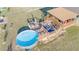 Backyard featuring a multi-tiered deck, a built-in seating area, and a round above ground pool at 2801 Sw 139Th St, Ocala, FL 34473