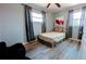 Cozy bedroom with wood-look floors, a ceiling fan, and large windows dressed with gray curtains at 331 Greens End St, Orlando, FL 32810