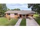 Well-maintained single-story home featuring a brick walkway, an inviting carport, and charming curb appeal at 331 Greens End St, Orlando, FL 32810