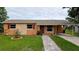 Charming single-story home featuring a well-manicured lawn and a brick pathway leading to the front door at 331 Greens End St, Orlando, FL 32810