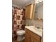 Traditional bathroom features a shower with patterned curtain, wood vanity, and mirrored medicine cabinet at 361 Dreama Dr, Davenport, FL 33897