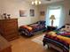 Bedroom featuring two twin beds, and wooden dresser in a brightly lit room with cartoon decor at 361 Dreama Dr, Davenport, FL 33897