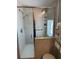Shower with glass enclosure, grab bar, tile surround, handheld shower head, and ornate glass window at 361 Dreama Dr, Davenport, FL 33897