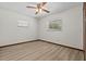 Sunlit bedroom shows light wood flooring, two windows and a ceiling fan at 3942 Orange Lake Dr, Orlando, FL 32817
