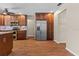 Stainless steel fridge and wood cabinets in an open-concept kitchen with wood floors at 3942 Orange Lake Dr, Orlando, FL 32817