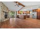 Open-concept living space with vaulted ceilings, stone fireplace, wood floors, and modern kitchen at 3942 Orange Lake Dr, Orlando, FL 32817