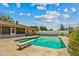 Backyard view of a large swimming pool with diving board and the rear exterior of the house at 3942 Orange Lake Dr, Orlando, FL 32817