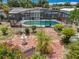 An elevated view of a house with a pool, fountain, plants, brick pavers, and a screen enclosure at 4021 Queen Anne Dr, Orlando, FL 32839