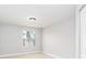 A simple bedroom with neutral walls, tiled floor, a window, and a door at 4528 Commander Dr # 2033, Orlando, FL 32822
