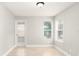 Bright bedroom featuring neutral paint, two windows, a tiled floor, and a glass panel door at 4528 Commander Dr # 2033, Orlando, FL 32822