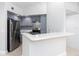 Well-lit kitchen boasts stainless steel appliances, gray cabinetry, and a sleek counter at 4528 Commander Dr # 2033, Orlando, FL 32822