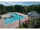 A community pool and hot tub area features lush vegetation, a covered spa, and black metal safety fencing at 4528 Commander Dr # 2033, Orlando, FL 32822