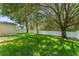 Spacious back yard featuring lush green grass and mature shade trees with a privacy fence at 476 Basking Ridge Ct, Ocoee, FL 34761