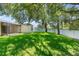 Large, well-maintained backyard with healthy green grass, mature trees, and an enclosed screened in porch at 476 Basking Ridge Ct, Ocoee, FL 34761