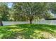 Lush green backyard with a large tree and a white picket fence defining the property line at 476 Basking Ridge Ct, Ocoee, FL 34761
