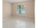 Neutral bedroom features tiled floor, a window letting in natural light and neutral paint at 476 Basking Ridge Ct, Ocoee, FL 34761