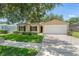 Single-Gathering home featuring an attached two car garage, manicured lawn, and mature landscaping at 476 Basking Ridge Ct, Ocoee, FL 34761