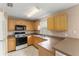 Efficient kitchen featuring tile floors, wood cabinets, and ample counter space for meal preparation at 476 Basking Ridge Ct, Ocoee, FL 34761